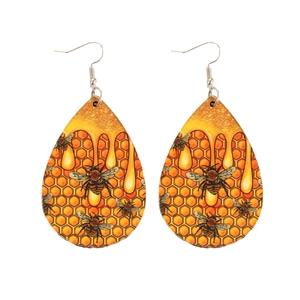 Bohemian teardrop wood earrings with bee and honeycomb print on white background