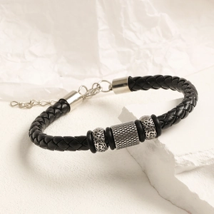 Vista detallada de pulsera de cuero trenzado con cuentas metálicas plateadas y cadena