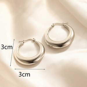 Detailed view of 3cm polished silver hoop earrings with clasp on silk fabric