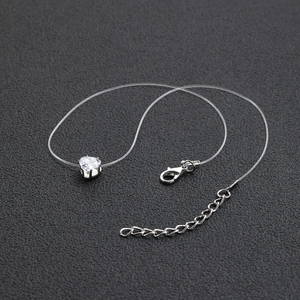 Detailed view of heart-shaped zircon pendant with transparent invisible fish line and clasp