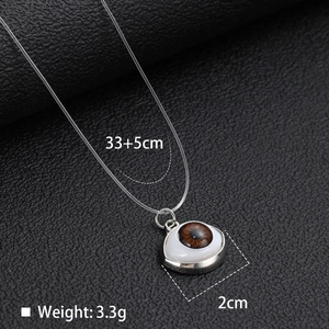 Detailed view of evil eye pendant with brown iris texture and 33+5cm fishing line chain