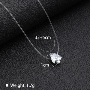 Macro view of pear-cut zircon pendant with transparent fishing line on black leather
