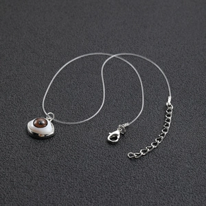Invisible fishing line necklace with a brown evil eye pendant on black leather