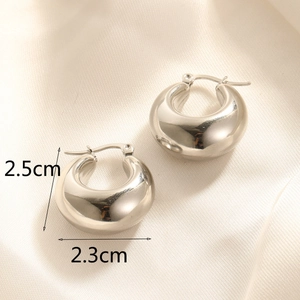 Polished silver puffed hoop earrings measuring 2.5cm by 2.3cm on silk background