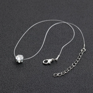 Detailed view of the clear fishline necklace with a sparkling round zircon pendant