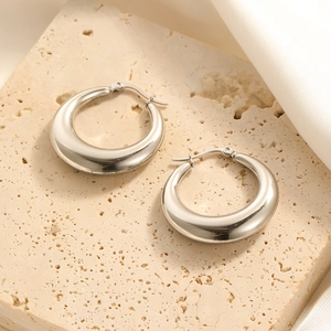 Chic silver-toned thick hoop earrings with smooth finish on a luxury stone background