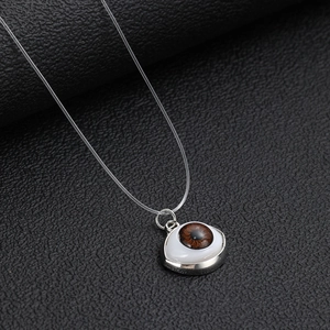 Invisible fishline necklace with unique brown evil eye pendant and silver metal base