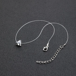 Macro detail of triangle zircon pendant with transparent invisible fishing line necklace