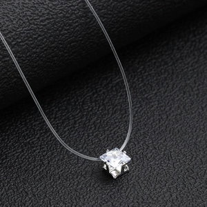 Floating square zircon pendant on a transparent fishing line necklace shown on black leather