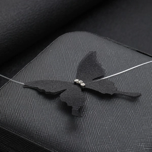 Detail of a black tulle butterfly pendant with sparkling rhinestones on a thin choker chain