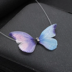 Macro shot of 3D gradient blue-purple tulle butterfly pendant with sparkling rhinestones