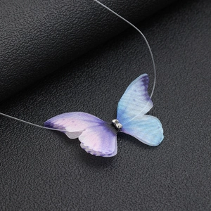 Detailed close-up of a blue-purple tulle butterfly necklace on a transparent fishing line