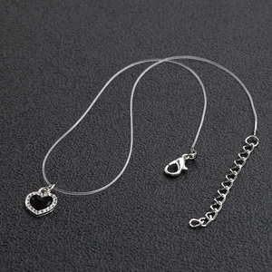 Collar minimalista de corazón negro con diamantes en un cordón transparente e invisible