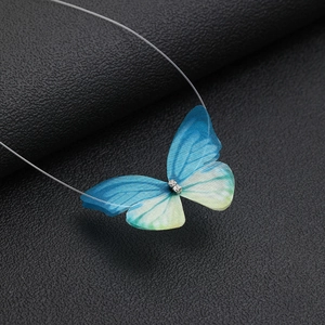 Detailed macro view of a 3D gradient blue tulle butterfly pendant on invisible line