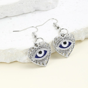Macro view of silver heart earrings with blue evil eye inlay and crystals