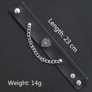 Detail of vintage wide leather punk bracelet with silver shield badge and metal chain decoration