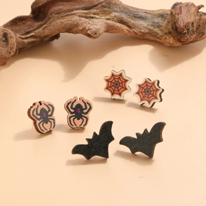 Détail de boucles d'oreilles en bois d'Halloween avec araignée et chauve-souris