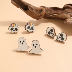 Détail de boucles d'oreilles Halloween en bois avec motifs de crâne et fantôme
