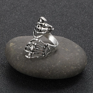Detailed view of vintage punk ring featuring double skull hands in silver finish
