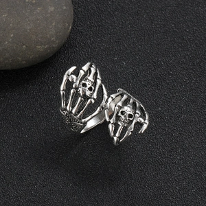 Retro punk skull ring for men featuring detailed bone hands in a vintage silver finish