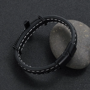 Detail of black leather bracelet with white stitching and puzzle-style magnetic buckle