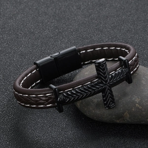 Detail view of men's brown leather bracelet with cross charm and magnetic clasp
