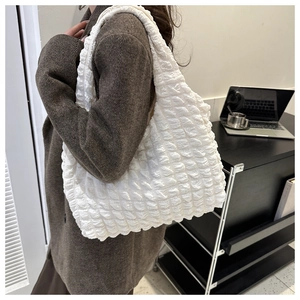 Detail of white popcorn texture tote bag showing pleated fabric and elastic bubble design
