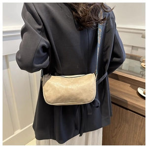 Detail view of light brown vintage leather crossbody bag with ethnic jacquard wide strap