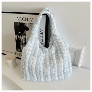 Detail of blue and white striped popcorn bubble texture on soft crescent shoulder bag