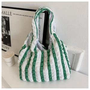Close-up of green and white striped puffy tote bag with puckered fabric texture