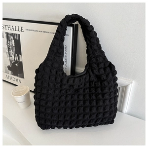 Detail of black popcorn texture material on a large capacity tote bag with soft handles