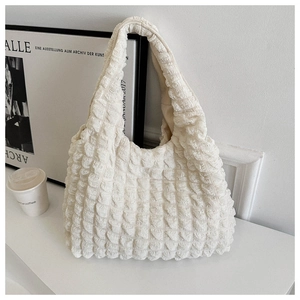 Close-up of a cream-white tote bag featuring a 3D bubble waffle texture and chic design