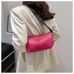 Magenta underarm bag with ethnic pattern wide shoulder strap on a white blazer outfit