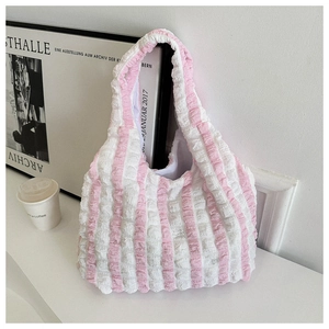 Detailed close-up of the bubble fabric texture and pink striped pattern of the tote bag