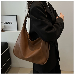 Detail of vintage brown leather tote bag showing textured finish and casual slouchy shape
