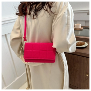 Detalle de bolso bandolera acolchado rojo rosa con hebilla dorada en gabardina beige