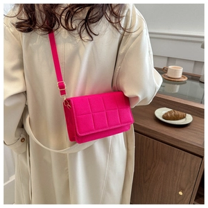 Primer plano del bolso acolchado fucsia con ganchos dorados y textura de gamuza