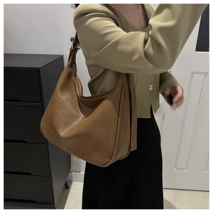 Detailansicht der karamellbraunen Hobo-Tasche mit Litschimaserung und Schultergurt-Design