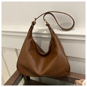 Detail of vintage brown hobo bag showing textured faux leather and gold hardware