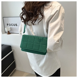 Detalle de bolso bandolera acolchado verde con solapa cuadrada y diseño moderno actual