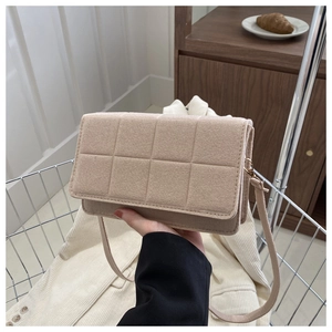 Detalle del bolso bandolera acolchado beige con tela suave y correa delgada fija