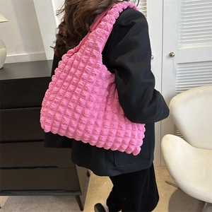 Pink popcorn texture shoulder tote bag for women shown against a black blazer background