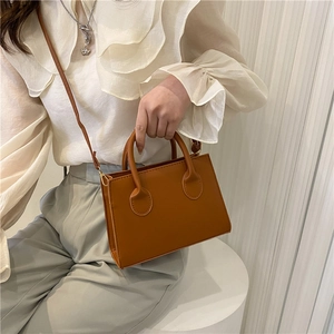 Classic caramel brown crossbody handbag in a minimalist rectangular design for daily wear