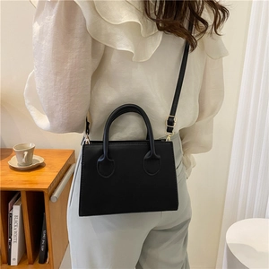 Minimalist black rectangle crossbody bag with gold hardware and top handles
