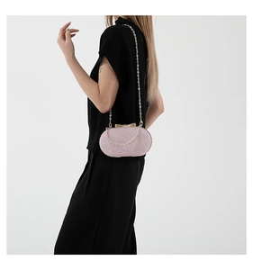 Detail of light pink sequin evening bag with gold bow clasp and metallic chain strap