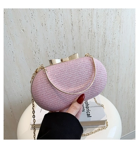 Detailed close-up of pink glitter evening bag with golden bow clasp and chain strap