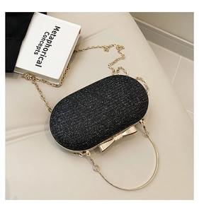 Close-up of black glitter evening bag with gold ring handle and butterfly clasp
