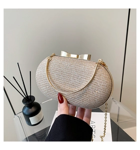 Detail of champagne gold glitter evening clutch with bow clasp and fine chain strap