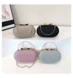 Close-up of glitter oval evening clutch bags with bow clasp and metal chain straps