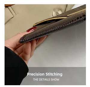 Detail view of precision stitching on dark brown crocodile embossed leather clutch bag